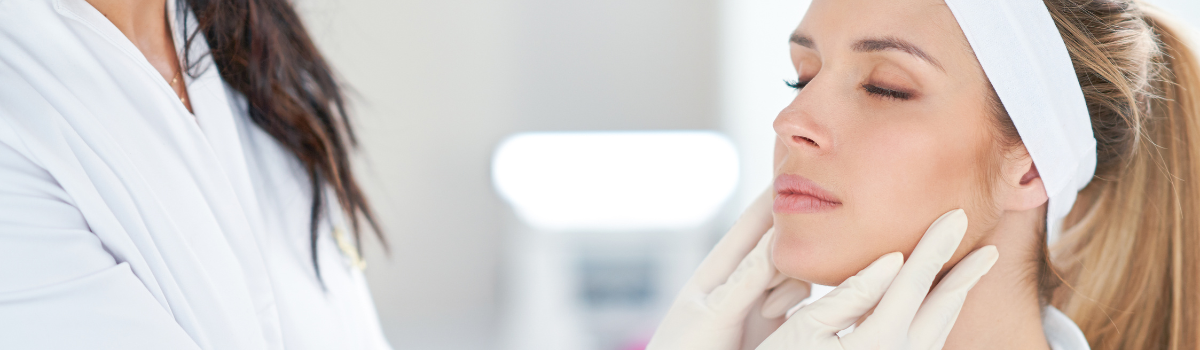 Doctor assessing a patient's face during a dermal filler consultation